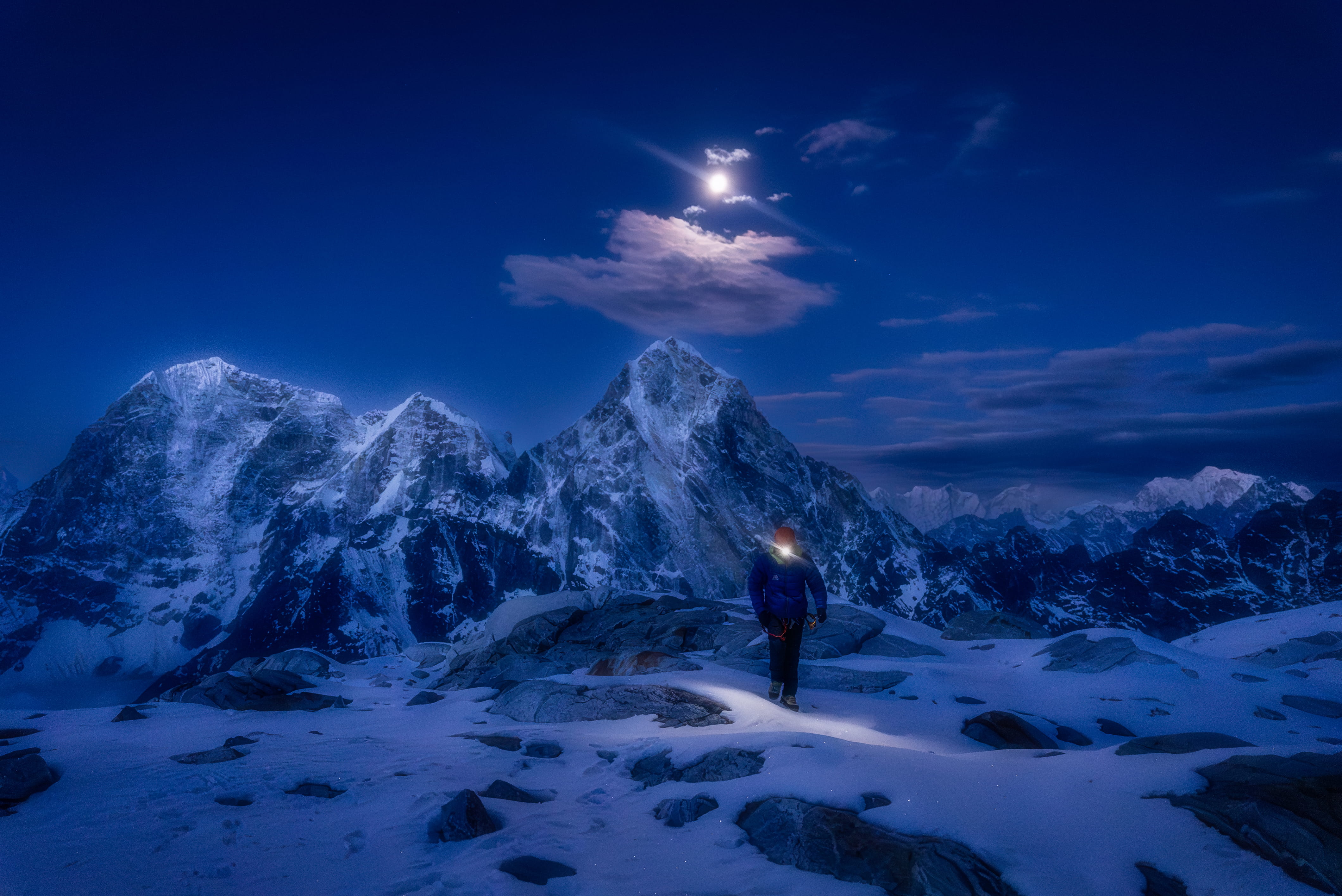 Climber on a moonlit ridge in the Himalayas
